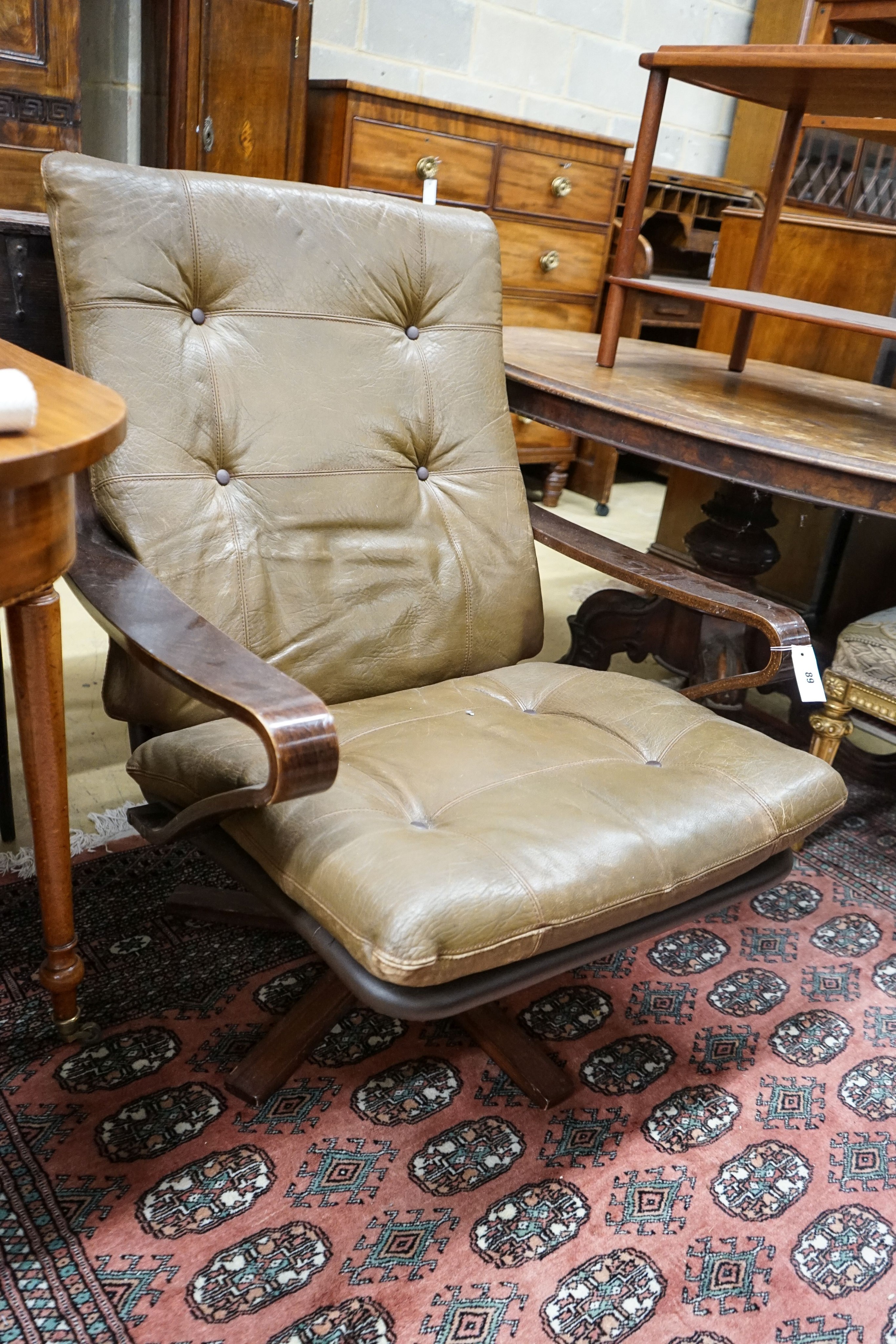 A mid century swivel chair with leather cushion upholstery, width 77cm, depth 75cm, height 94cm